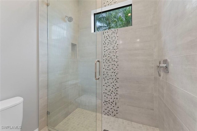 bathroom with a stall shower and toilet