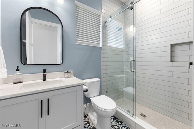 full bathroom featuring a shower stall, toilet, and vanity