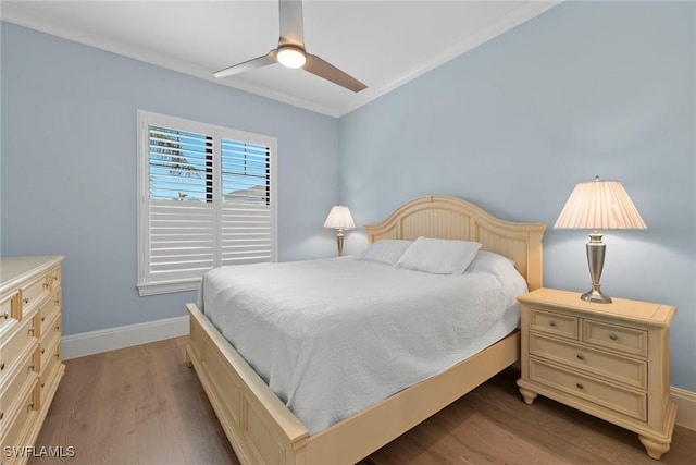 bedroom with baseboards, wood finished floors, and a ceiling fan