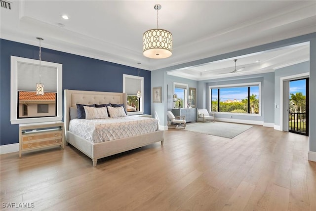 bedroom featuring baseboards, a raised ceiling, wood finished floors, and access to exterior