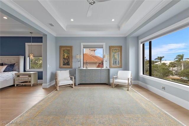 sitting room featuring visible vents, a raised ceiling, baseboards, and wood finished floors