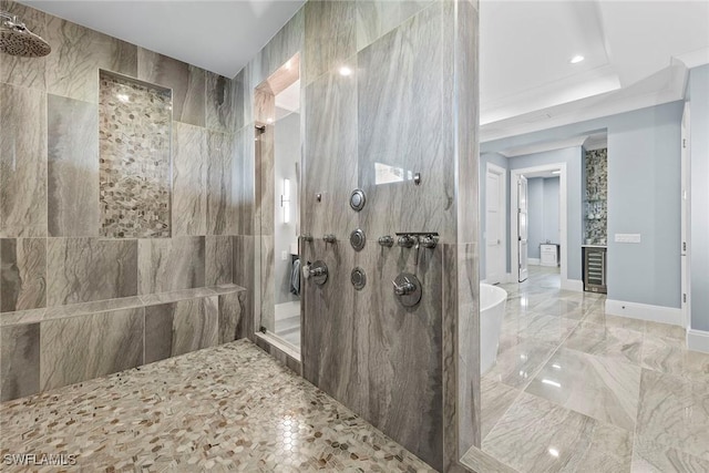 bathroom featuring a soaking tub, marble finish floor, baseboards, and walk in shower