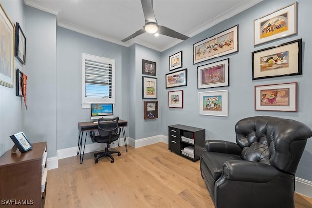 office space featuring light wood-type flooring, baseboards, a ceiling fan, and crown molding