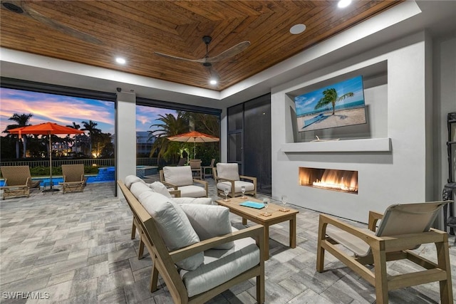 cinema room featuring a raised ceiling, wooden ceiling, recessed lighting, and a warm lit fireplace