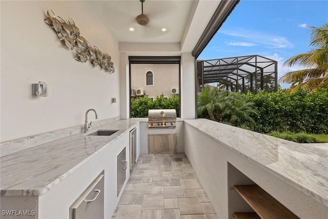 view of patio / terrace featuring glass enclosure, exterior kitchen, outdoor wet bar, a sink, and a grill