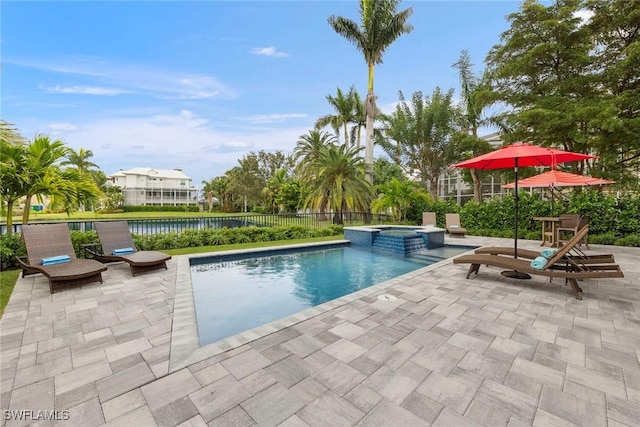 view of swimming pool featuring a patio area, a pool with connected hot tub, and fence