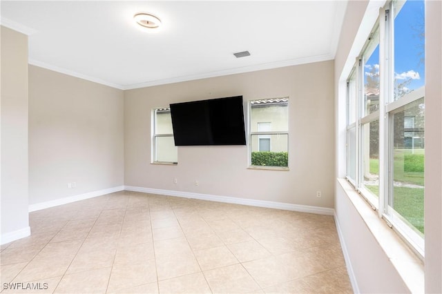 spare room with light tile patterned floors, baseboards, and ornamental molding