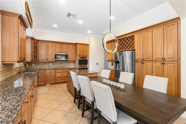 kitchen featuring a sink, visible vents, appliances with stainless steel finishes, dark stone countertops, and glass insert cabinets