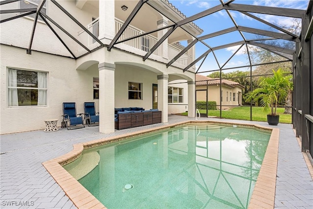 outdoor pool with a lanai, outdoor lounge area, and a patio