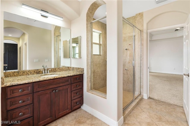 bathroom with baseboards, tile patterned flooring, vanity, and a shower stall