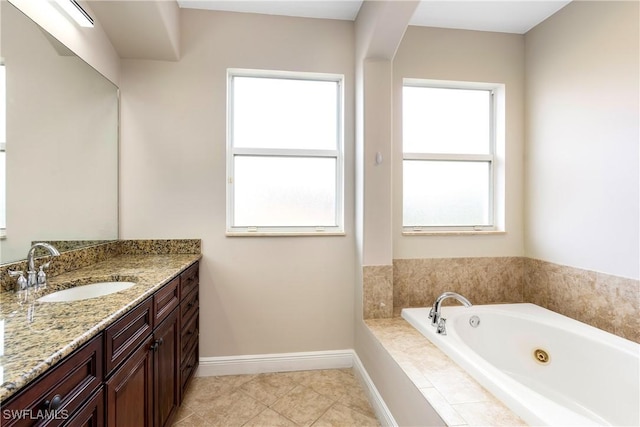 full bathroom with tile patterned flooring, a whirlpool tub, vanity, and baseboards