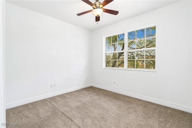 spare room with carpet flooring, a ceiling fan, and baseboards