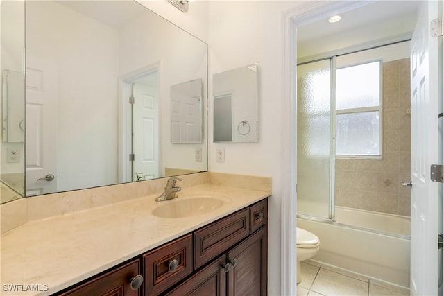 bathroom with combined bath / shower with glass door, vanity, toilet, and tile patterned floors