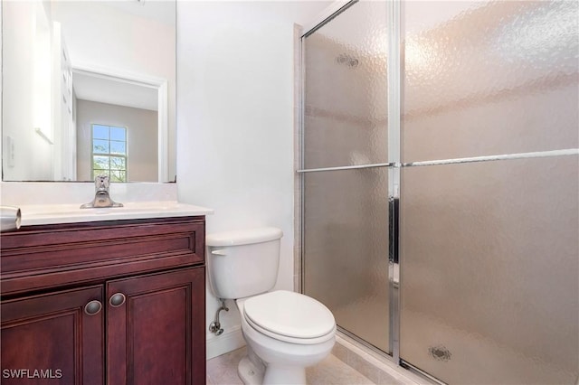 bathroom with a stall shower, vanity, and toilet