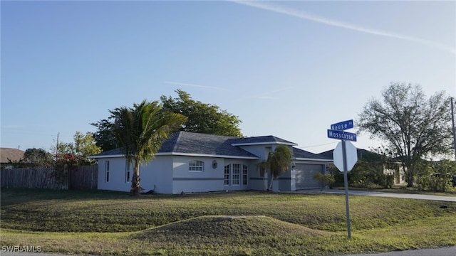 single story home with a garage, a front yard, fence, and stucco siding