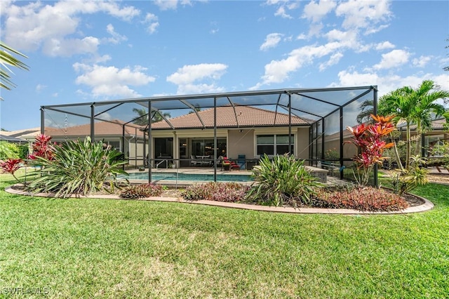 rear view of house featuring a yard, stucco siding, a lanai, and an outdoor pool