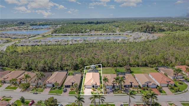 birds eye view of property featuring a water view, a residential view, and a wooded view