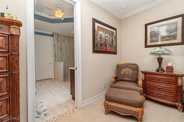 sitting room with ceiling fan, crown molding, baseboards, and light tile patterned floors