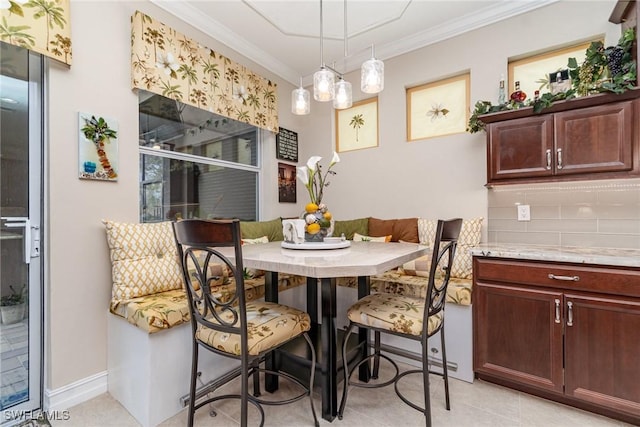 dining room featuring light tile patterned floors, ornamental molding, and breakfast area