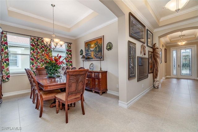 dining area with plenty of natural light, arched walkways, a raised ceiling, and a notable chandelier