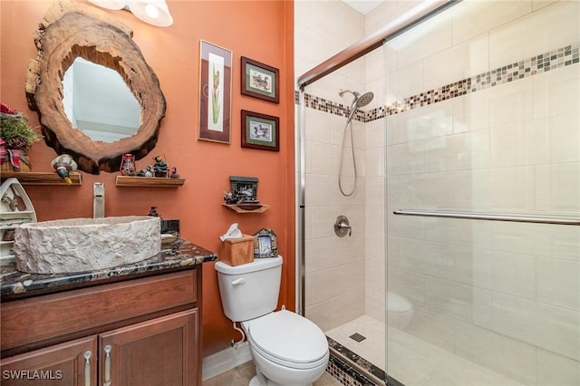 full bathroom with vanity, a shower stall, and toilet