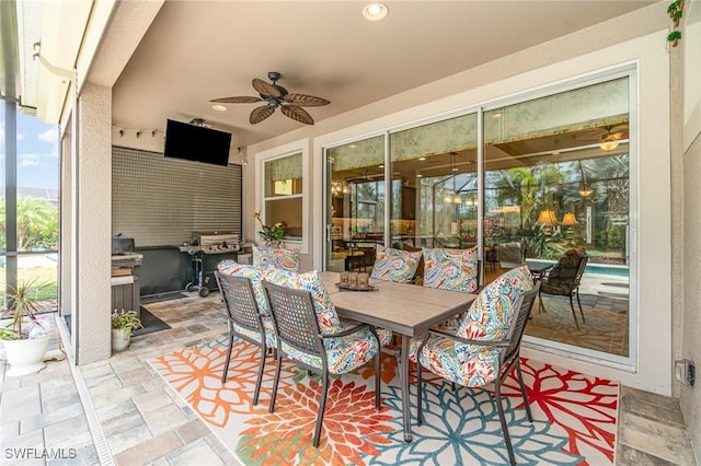 view of patio featuring outdoor dining space, ceiling fan, and area for grilling