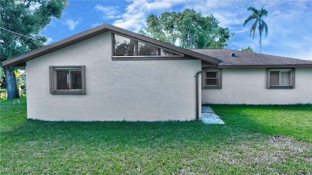 exterior space featuring a lawn and stucco siding