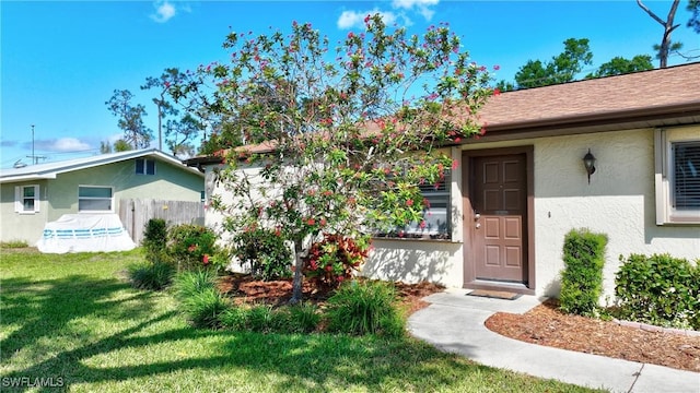 entrance to property with a yard and stucco siding