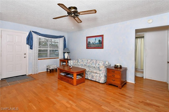 living area featuring ceiling fan, a textured ceiling, and wood finished floors