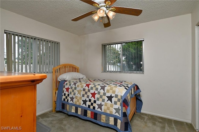 carpeted bedroom featuring a ceiling fan, baseboards, and a textured ceiling