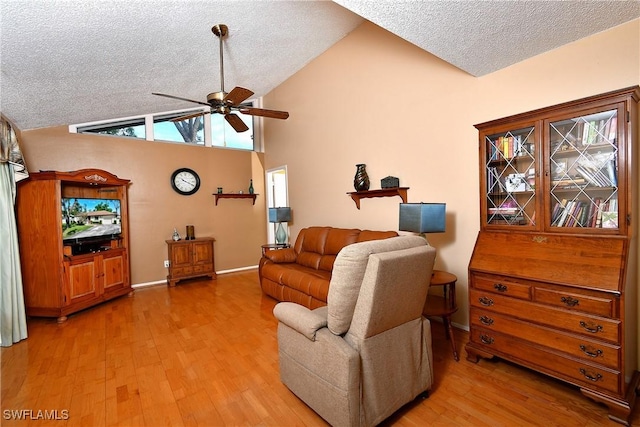 living area featuring a textured ceiling, vaulted ceiling, and wood finished floors