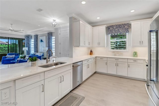 kitchen featuring open floor plan, light countertops, a sink, and stainless steel dishwasher