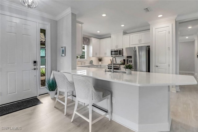 kitchen featuring visible vents, white cabinets, appliances with stainless steel finishes, light countertops, and a sink