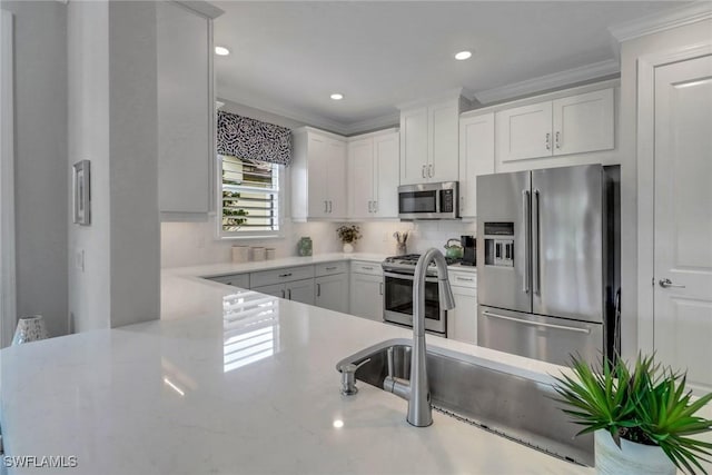 kitchen with recessed lighting, stainless steel appliances, white cabinetry, tasteful backsplash, and crown molding