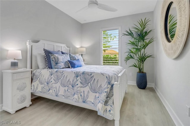 bedroom featuring light wood-type flooring, baseboards, and a ceiling fan