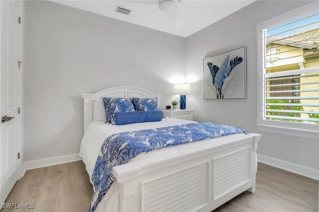 bedroom featuring visible vents, baseboards, and wood finished floors