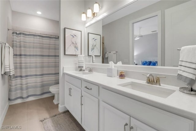 bathroom featuring double vanity, tile patterned flooring, a sink, and ensuite bathroom