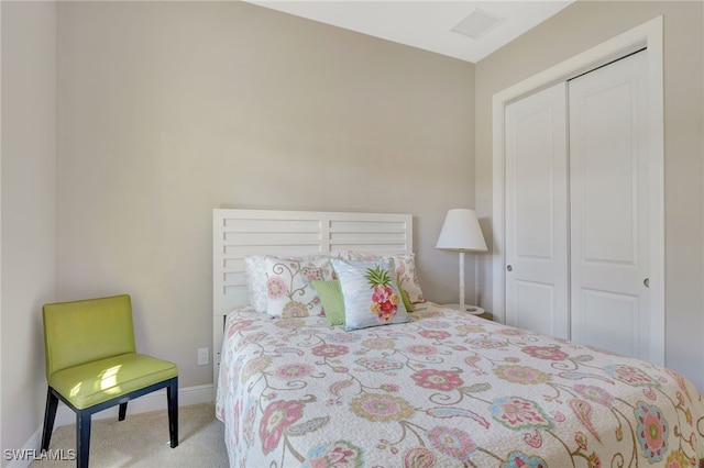 bedroom featuring baseboards, visible vents, a closet, and light colored carpet