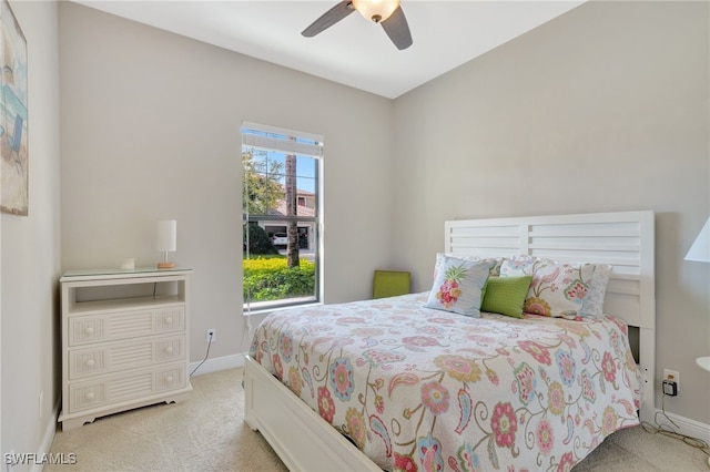 bedroom with light carpet, ceiling fan, and baseboards