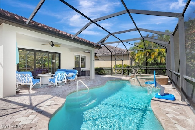 view of pool featuring a patio, a pool with connected hot tub, outdoor lounge area, a ceiling fan, and a lanai