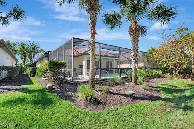 exterior space with a lawn, a lanai, and an outdoor pool