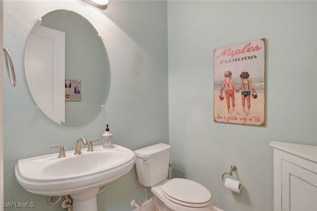 half bathroom featuring toilet and a sink