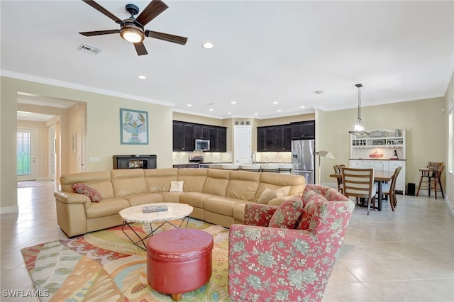 living area featuring light tile patterned floors, visible vents, crown molding, and recessed lighting