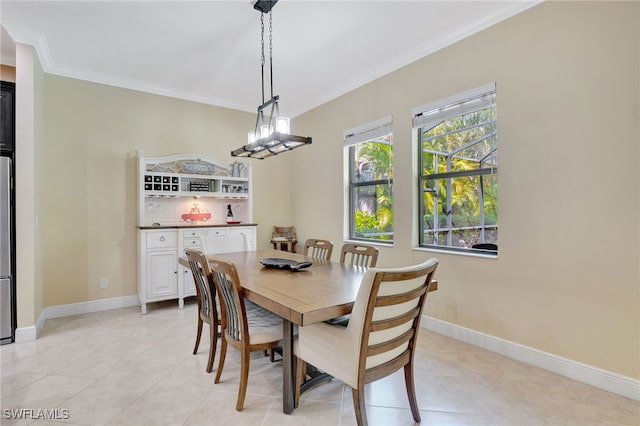 dining space featuring baseboards, light tile patterned floors, and crown molding