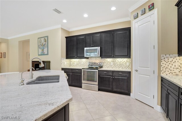 kitchen featuring light tile patterned floors, stainless steel appliances, a sink, visible vents, and light stone countertops