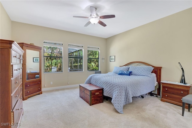 bedroom featuring light carpet, ceiling fan, and baseboards