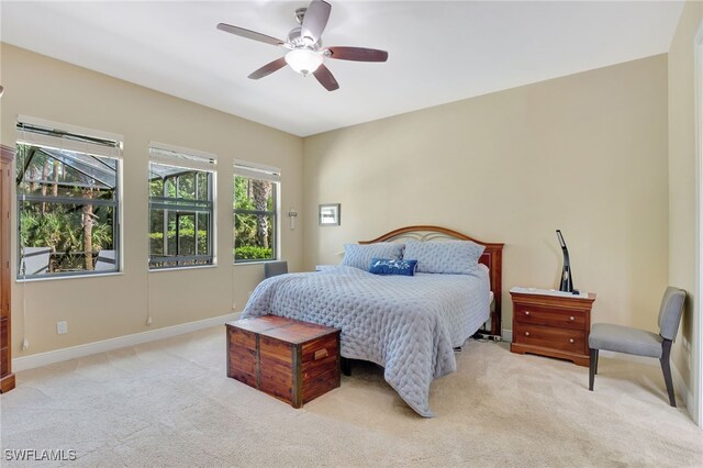 bedroom with baseboards, a ceiling fan, and light colored carpet