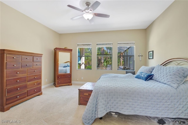 bedroom featuring a ceiling fan, light colored carpet, and baseboards