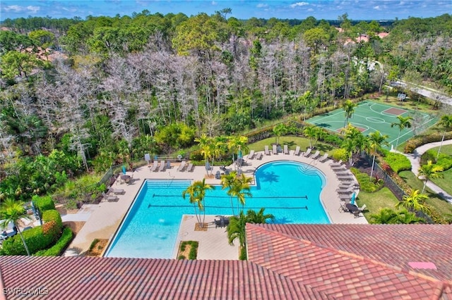 pool with community basketball court, fence, and a patio