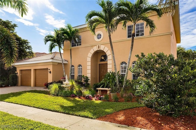 mediterranean / spanish-style home with an attached garage, a tile roof, concrete driveway, and stucco siding